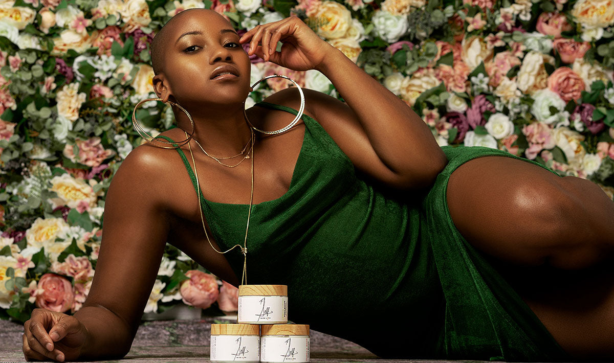 woman in a green dress posing with body butters